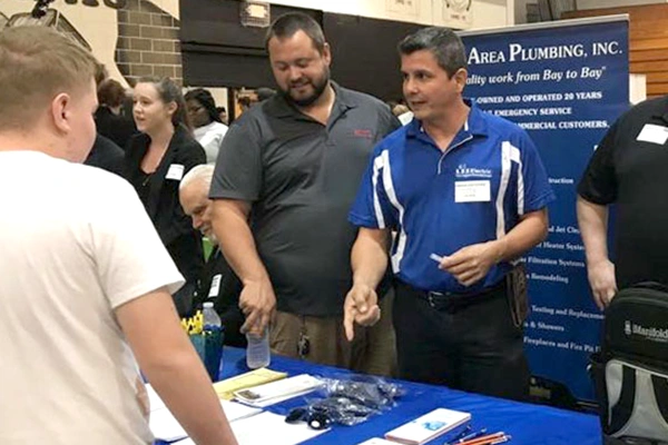 Luis Espel at an event speaking to others about their services